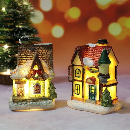 Two illuminated miniature Christmas houses with a festive background.
